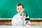 Smart stylish schoolboy used microscope on lesson