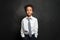 Smart successful serious black child boy student on black background