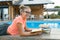 Smart teenage girl in glasses reading book, teenager near house