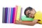 Smart toddler with glasses sleeping with books