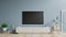 Smart Tv Mockup on cabinet with blank screen hanging have plants shelf lamp on blue wall