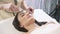 Smart woman getting ultrasonic face procedure in beauty parlor