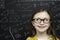 Smart young girl stood infront of a blackboard