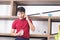 Smart, young and healthy Asian man with casual  red t-shirt having breakfast work from home. Young man using mobile phone in the