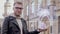 Smart young man with glasses shows a conceptual hologram stacks of money