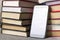 Smartphone among books, many books, 2 stacks of books