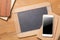 Smartphone, chalkboard, pencil, notebooks on wooden table background