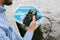 Smartphone with charging from Power bank in a man`s hand. Against the background of a boat on the water