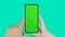 Smartphone with chromakey screen in hand. Finger touches empty display of mobile phone.