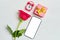 Smartphone copy space with a one red roses, watches, gift box on a white wooden background