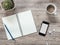 Smartphone, earphones, notebook and coffee on wooden background