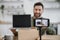Smartphone filming video of man doing unpacking of laptop