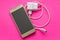 Smartphone Golden color and white USB charger on pink background