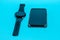 Smartphone in a gray textile case and a smart watch on a blue background. Clouse-up