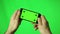 Smartphone With Green Screen Male Hands Detail Playing A Game In Landscape