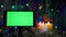Smartphone with a green screen. On a New Year`s background, flashing garlands, burning candles.