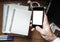 Smartphone in hand on messy wooden table