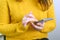 Smartphone in the hands of a woman in a yellow sweater