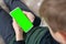 Smartphone with a hromakey in the hands of a child. Smartphone with a green screen in hand child