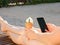 Smartphone and ice cream in female hands, side view, close-up. Summer, chaise longue