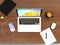 Smartphone, laptop, digital tablet and mug cup on wooden desktop