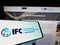 Smartphone with logo of institution International Finance Corporation (IFC) on screen in front of website.