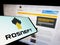 Smartphone with logo of Russian oil and gas company PJSC Rosneft on screen in front of business website.