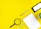 Smartphone, magnifying glass, notebook and succulent on yellow background. Job searching or distance learning concept.