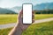 Smartphone mockup, man holding mobile phone with blank white screen as copy space over tranquil alpine meadow landscape in summer