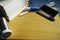 A smartphone and a pile of books are placed on a wooden table.