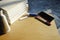 A smartphone and a pile of books are placed on a wooden table.