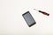 Smartphone and precision screwdriver over white