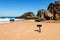Smartphone takenig photo of Rocky stone on beach at sunny day, Atlantic ocean coast