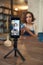 Smartphone on tripod with young craftswoman on screen