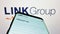 Smartphone with webpage of Australian financial company Link Group on screen in front of business logo.