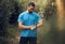 Smartwatch, fitness and forest man check workout results or digital training progress for outdoor wellness lifestyle