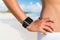 Smartwatch woman wearing fitness smart watch showing screen on beach. Wrist and hand on summer travel holiday person training run