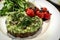 Smashed avocado on a slice of bread with roasted tomatoes