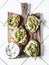 Smashed grilled eggplant bruschetta with yogurt herbs sauce - delicious appetizers, snacks, tapas on cutting board on a light