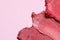 Smears of beautiful lipsticks on pink background, closeup