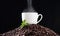 The smell of freshly-made coffee awakens the soul. Closeup shot of a mint leaf and a cup on a pile of coffee beans.