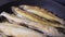 Smelt fish is fried in oil in a black pan. Close-up shot. Seafood cooking