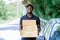 Smile african man postal delivery courier man in front of car delivering package