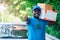 Smile african postal delivery courier man in front of car delivering package