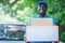 Smile african postal delivery courier man in front of car delivering package