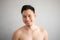 Smile Asian man in topless portrait isolated on gray background