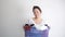 Smile Asian woman holding basket of used clothes for washing. Concept of housework.