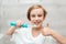 Smile boy cares about health of his teeth. Kid brushing teeth with electic brush in bathroom