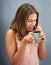 Smile, coffee and woman in studio for happiness, break and calm morning on gray background. Mug, cappuccino and female