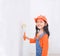 Smile cute asian little girl holding paint roller with copy space in the white room